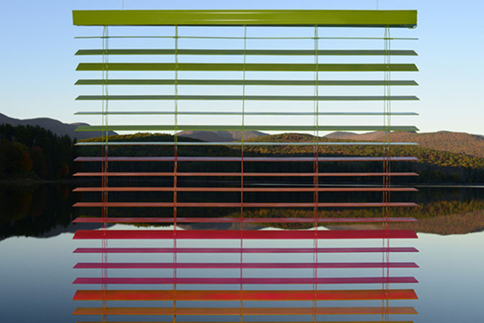 Landscape in background with what appears as blinds in foreground in red and green