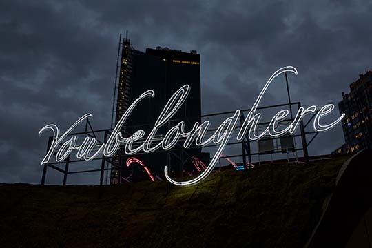 Tavares Strachan, We Belong Here, 2021. Neon, 532 x 176 in. (1351.3 x 447 cm) . Installation at Barclays Center, Brooklyn, New York, 2021. Courtesy of the artist and Marian Goodman Gallery. © Tavares Strachan.  