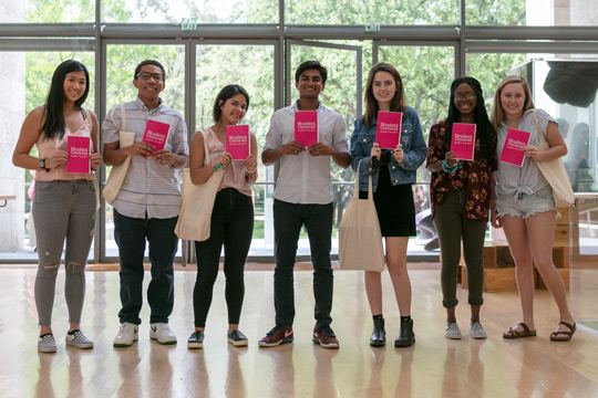 A group of students hold up copies of a zine