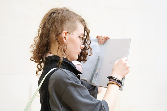 A student draws in a sketchbook