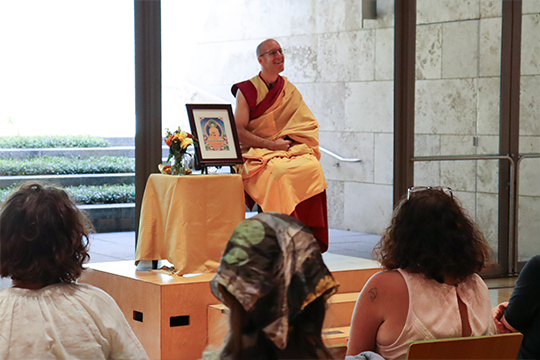 A man in Buddhist robes addresses a crowd