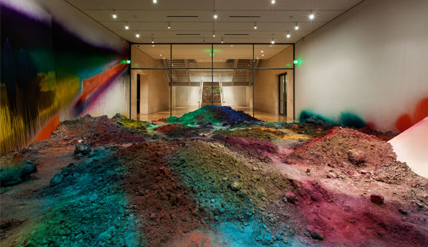 Mounds of brightly spray painted earth cover the gallery floor at Nasher Sculpture Center 