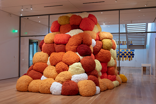 A sculptural installation by Sheila Hicks titled 'Sentinel of Saffron'