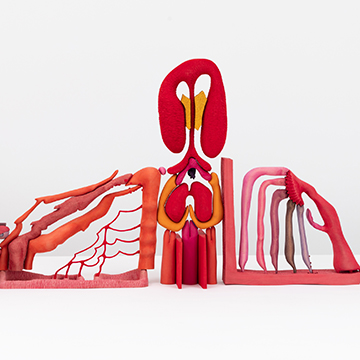 A bright red sculpture made of biomorphic shapes