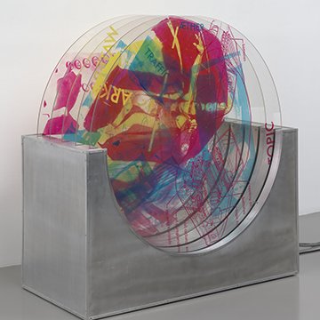 A sculpture featuring several round panes of plexiglass screenprinted with colorful images A sculpture featuring several round panes of plexiglass screenprinted with colorful images