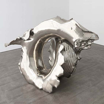 Image of highly reflective silver sculpture with a curving organic form