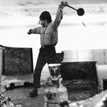 Artist Richard Serra flinging lead at a wall in his studio