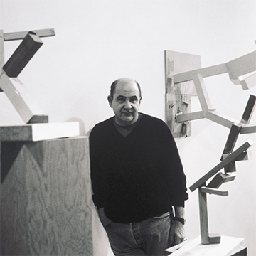 Artist Joel Shapiro standing among his sculptures