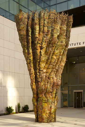 tall bronze sculpture by Ursula von Rydingsvard in front of a university campus building