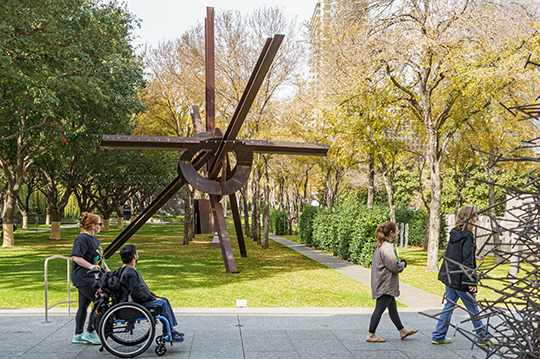 Visitors, including one in a wheelchair, move across the Nasher terrace.